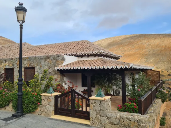The stone entrance of the house with a street lamp in front