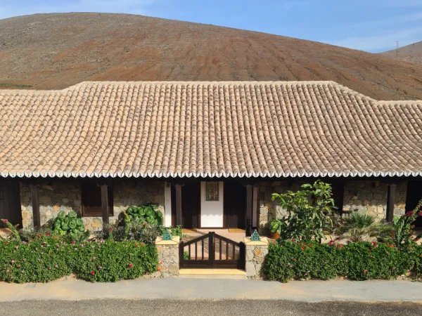 The front of the house with its terracotta roof and wooden gate