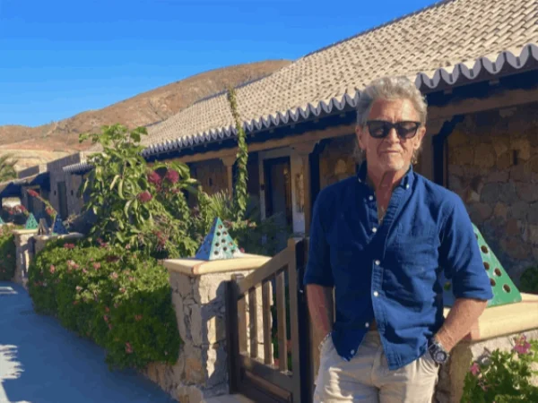 A man in a blue shirt at the garden gate