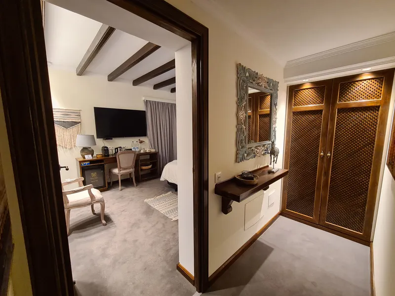 The entrance with a carved mirror and a latticed wardrobe, the bedroom beyond