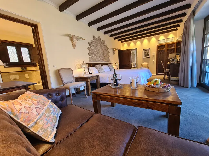 The leather sofa and the coffee table with wine and fruit, the bed beyond