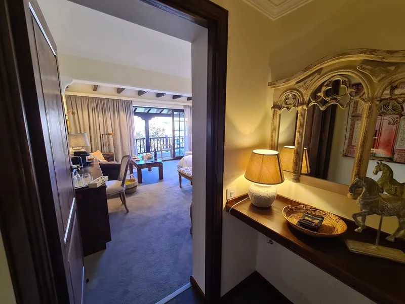 A dressing table with a carved mirror and a lamp