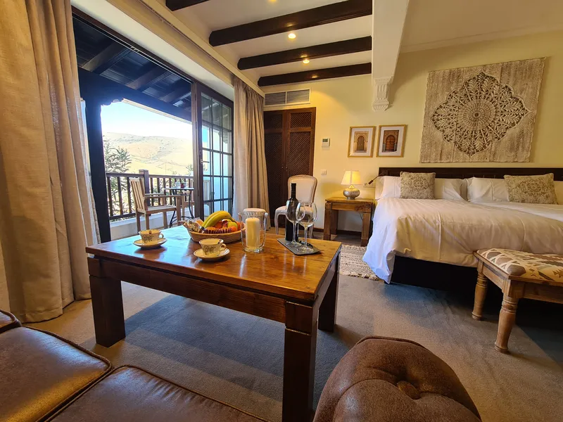 The coffee table with fruit and wine, the bed and the open terrace doors