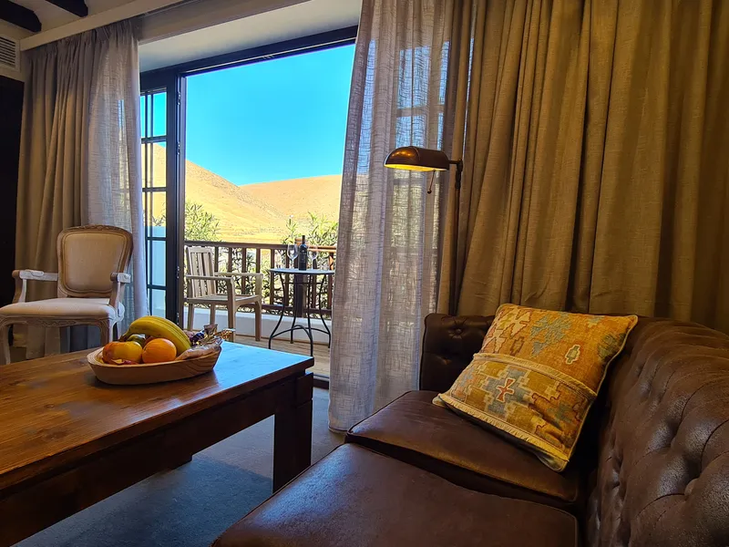 A leather sofa by the glass doors, with the mountains outside