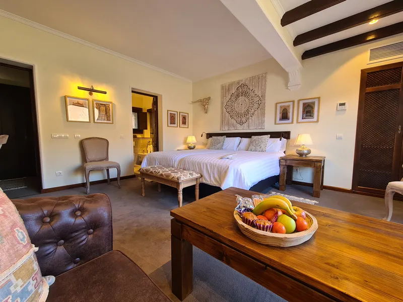 A coffee table with a bowl of fruit in front of the beds