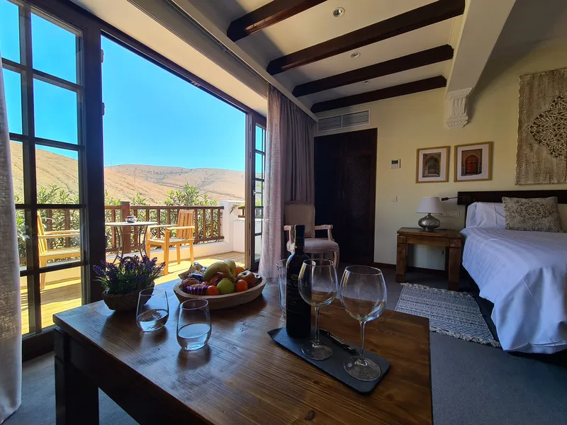 A table with fruit and glasses by the window to the mountains