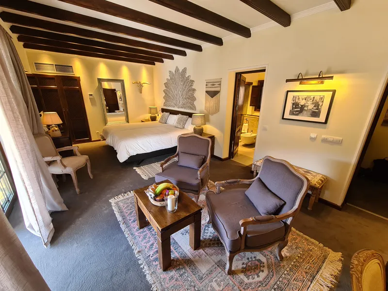 The armchairs and the coffee table beside the bed